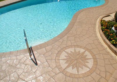 Custom pool deck with compass detail stamped into the concrete.