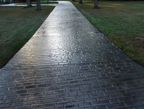 Long brick stamped concrete driveway, stained dark gray and polished.