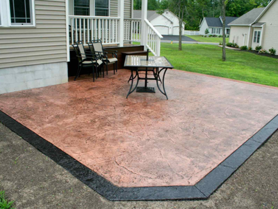 Polished and textured concrete patio with dark stained concrete border.