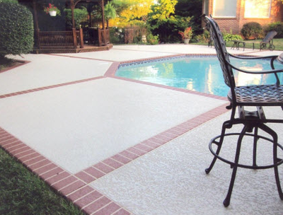 Concrete pool deck, textured with a brick patterned border.