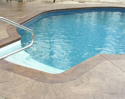 Indoor pool with stamped concrete deck, that's textured and stained.