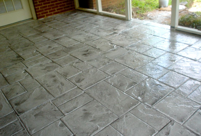 Indoor patio with stamped and colored concrete made to look like various sized brick pavers.