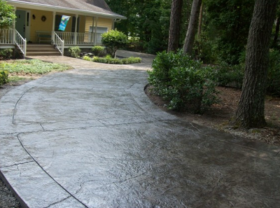 Dark stained concrete driveway stamped with a texture.